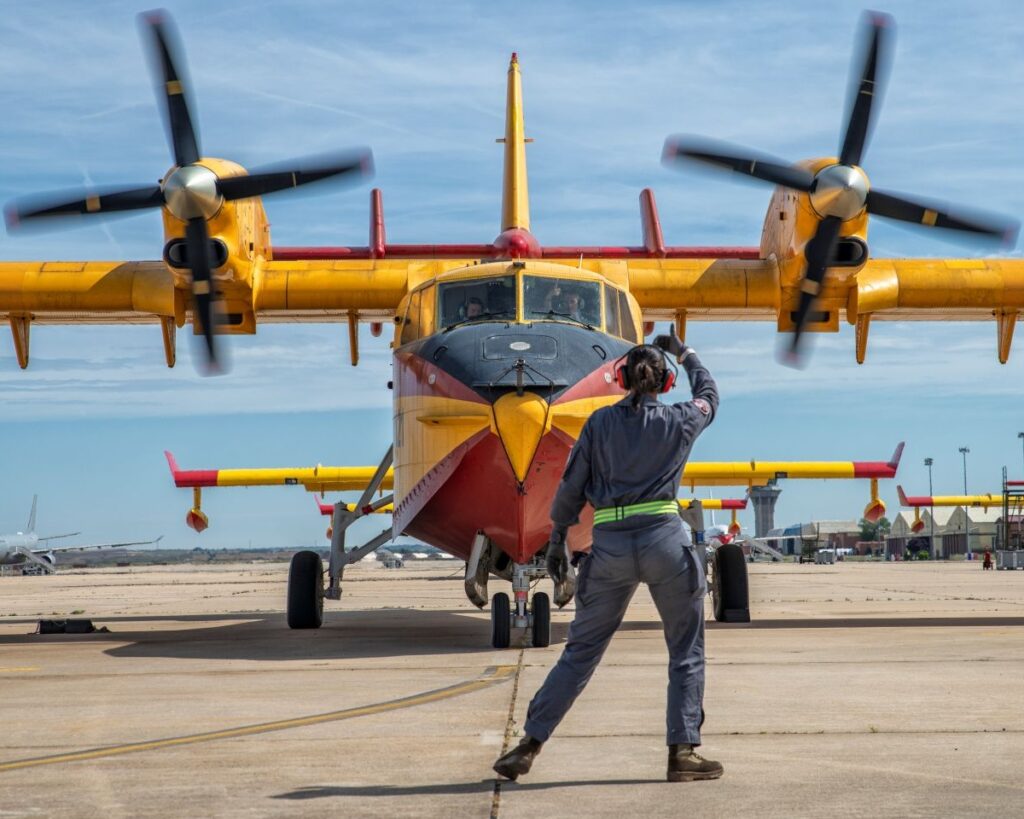 Avión del Grupo 43 del ejercito en pista visto de frente mientras personal de tierra hace indicaciones