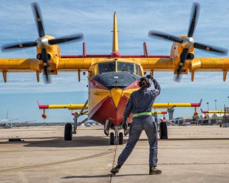 Avión del Grupo 43 del ejercito en pista visto de frente mientras personal de tierra hace indicaciones